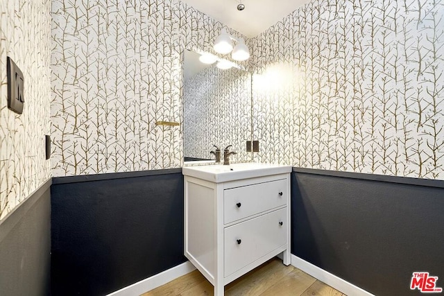 bathroom featuring hardwood / wood-style floors, a notable chandelier, and vanity