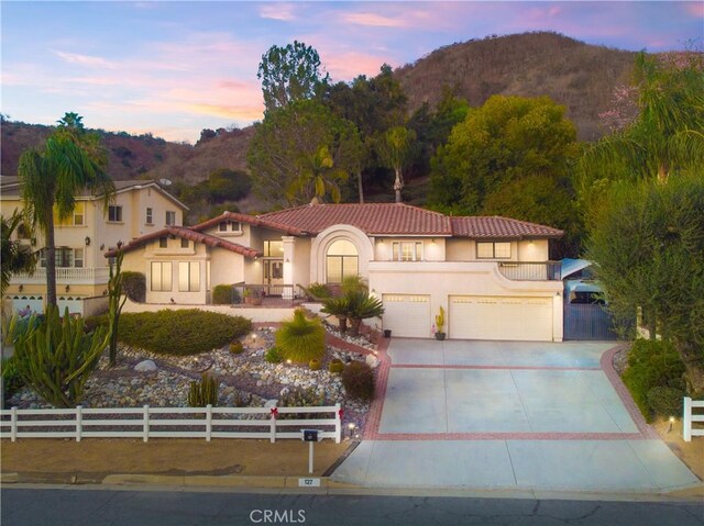 mediterranean / spanish-style home with a mountain view, a garage, and a balcony