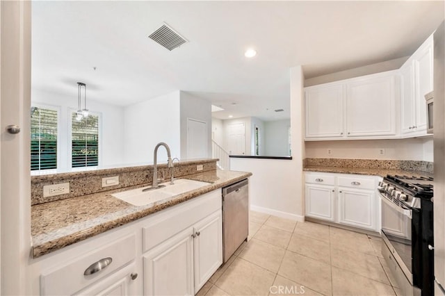 kitchen with pendant lighting, white cabinets, sink, appliances with stainless steel finishes, and light stone counters