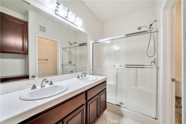 bathroom with tile patterned floors, vanity, and walk in shower