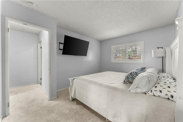 bedroom featuring light carpet and a textured ceiling