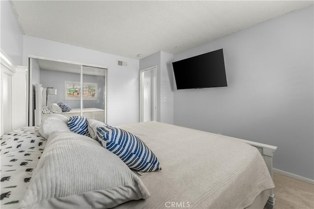 carpeted bedroom featuring a closet and a textured ceiling