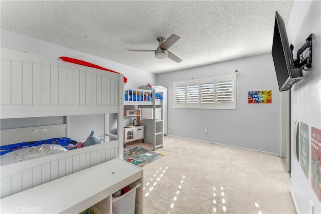 bedroom with a textured ceiling, light colored carpet, and ceiling fan