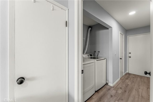 laundry room featuring light wood-type flooring and washing machine and clothes dryer