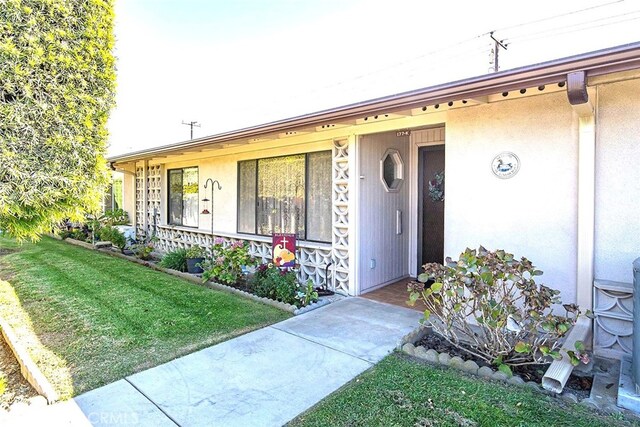 doorway to property featuring a lawn