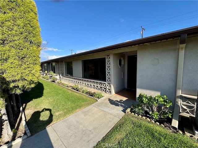 view of front of property featuring a front lawn and stucco siding