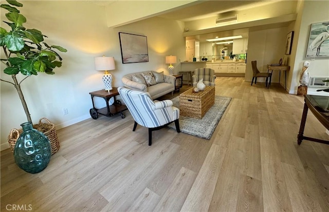 living area featuring light wood-type flooring and baseboards