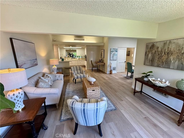 living room with light wood-style floors and a textured ceiling