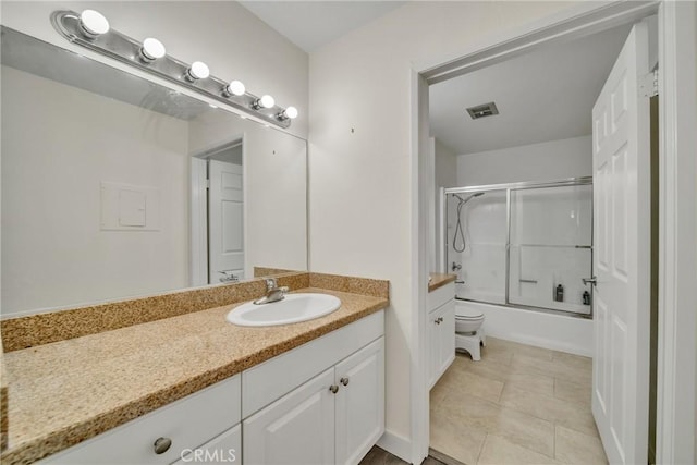 bathroom featuring vanity, tile patterned floors, and bath / shower combo with glass door