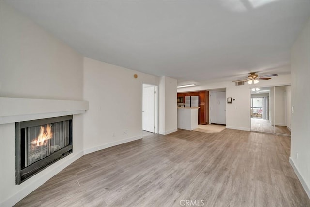 unfurnished living room featuring light wood-type flooring and ceiling fan