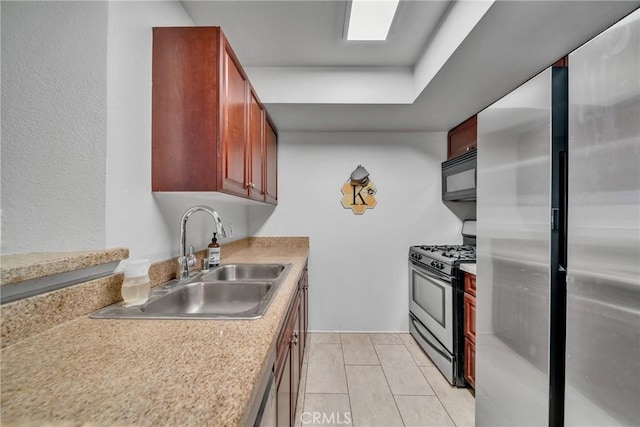 kitchen with appliances with stainless steel finishes, light tile patterned floors, and sink