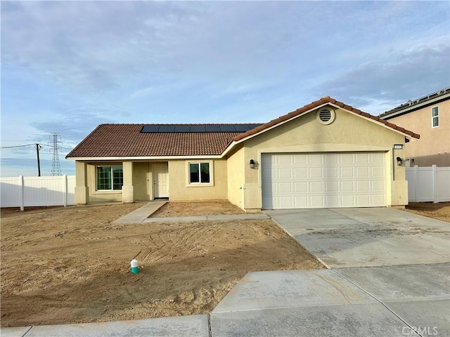 view of front of property featuring a garage and solar panels