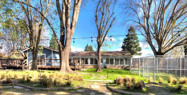 back of property with a wooden deck and a sunroom