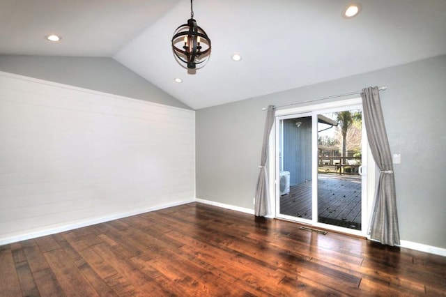 empty room with lofted ceiling, dark hardwood / wood-style floors, and a notable chandelier