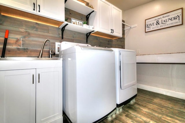 laundry room featuring dark wood-type flooring, sink, separate washer and dryer, and cabinets