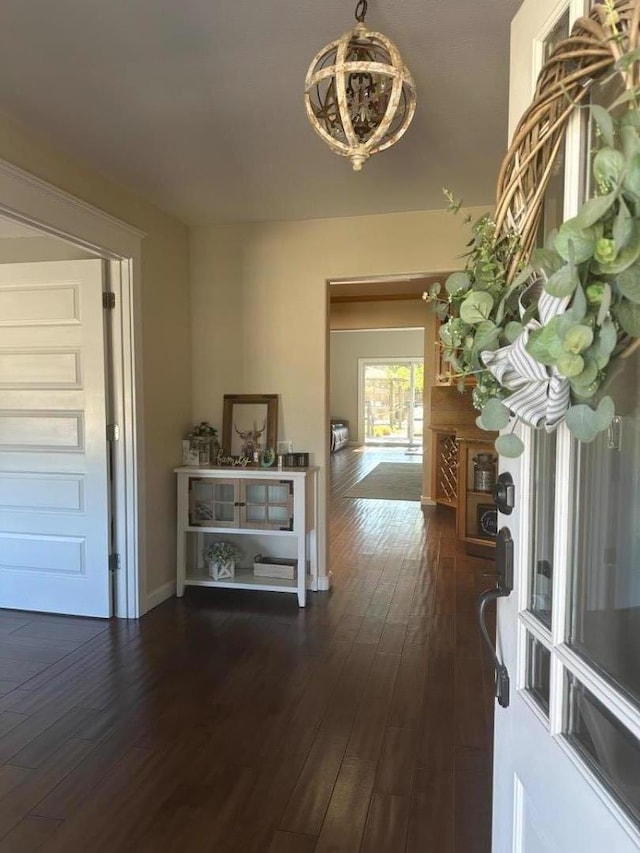 hallway featuring an inviting chandelier and dark hardwood / wood-style floors