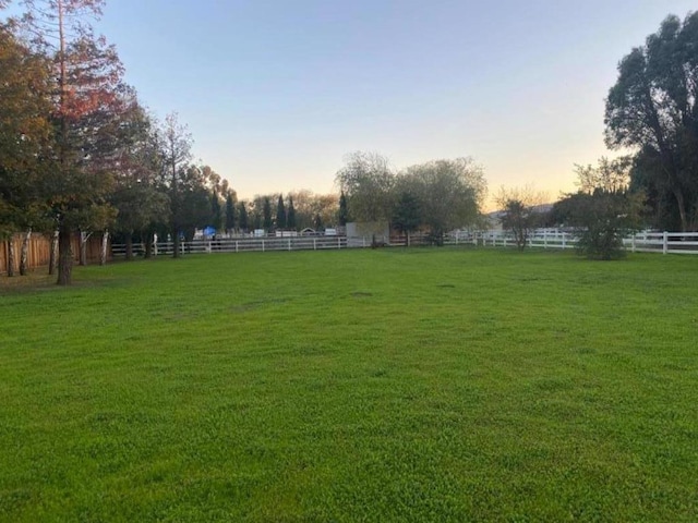 yard at dusk with a rural view