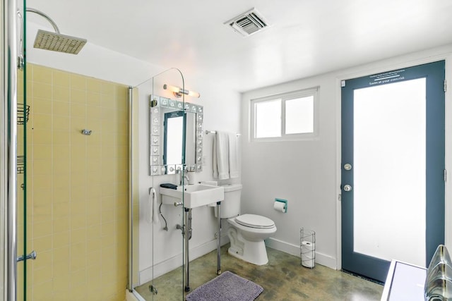 bathroom with a shower, concrete floors, and toilet