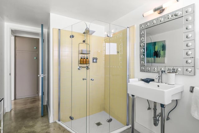 bathroom featuring a shower with door and concrete floors