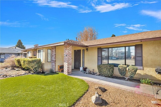 ranch-style home with a front lawn