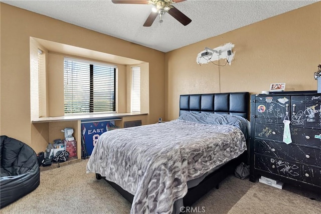 carpeted bedroom featuring ceiling fan and a textured ceiling