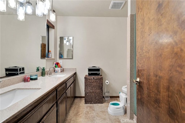 bathroom with toilet, vanity, and tile patterned floors