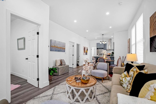 living room featuring a notable chandelier and dark wood-type flooring