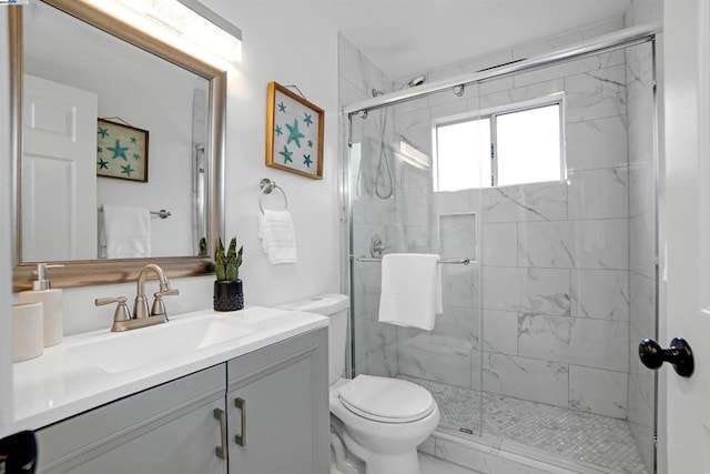 bathroom with vanity, toilet, and a shower with door