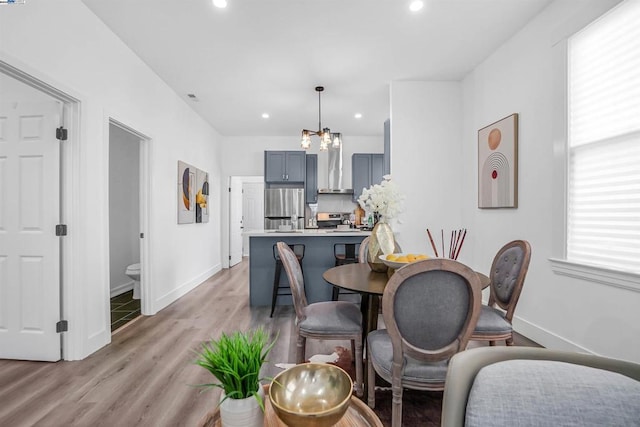 dining area featuring plenty of natural light, a chandelier, and light wood-type flooring