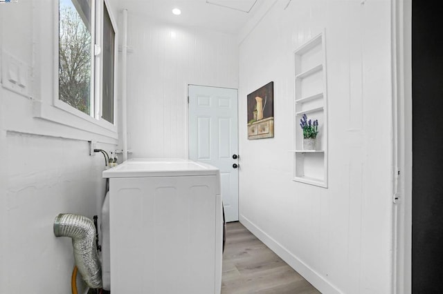 laundry area featuring built in shelves, light hardwood / wood-style floors, and washer / dryer