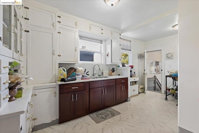 kitchen featuring decorative backsplash, sink, and white cabinetry