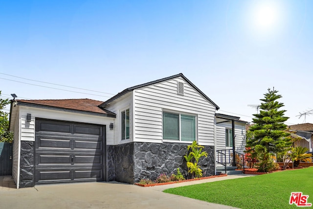 view of front of property featuring a front lawn and a garage