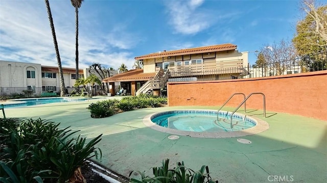 view of pool with a hot tub