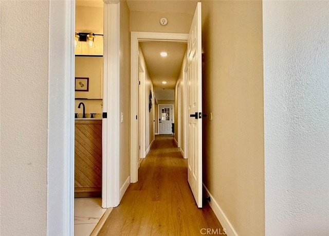 hall featuring sink and hardwood / wood-style floors