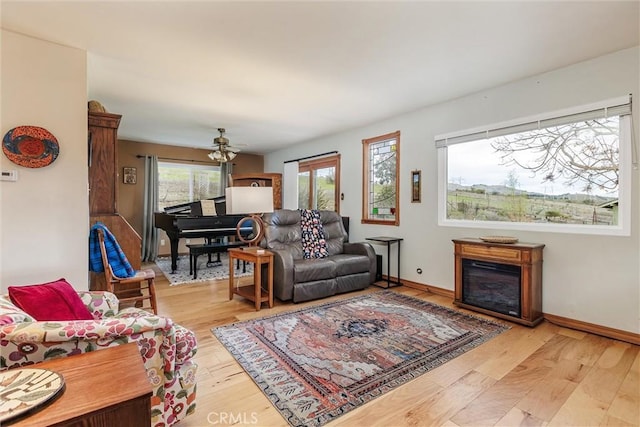 living room featuring ceiling fan and light hardwood / wood-style flooring