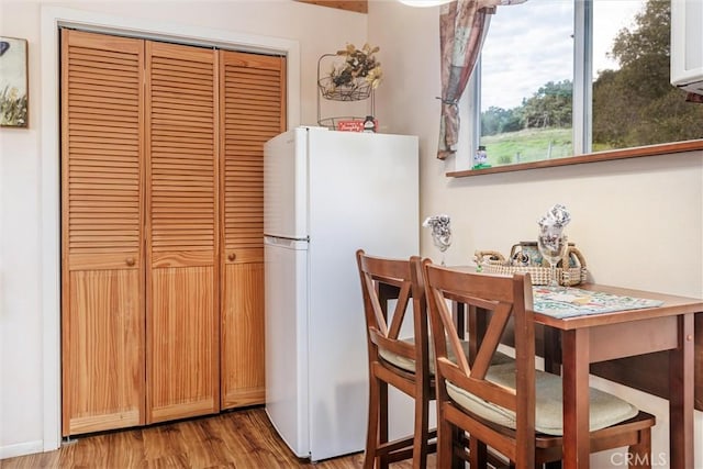 kitchen with white refrigerator and light hardwood / wood-style floors