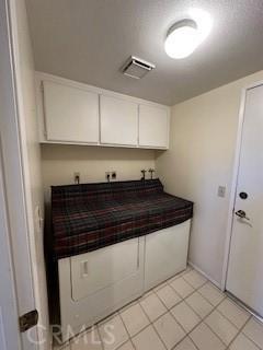 clothes washing area with light tile patterned floors