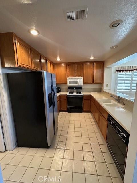 kitchen with light tile patterned floors, white appliances, and sink