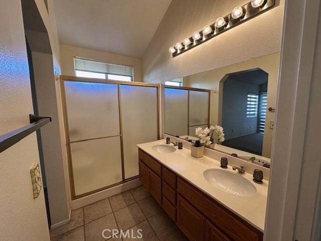 bathroom with vanity, tile patterned floors, a shower with shower door, and lofted ceiling