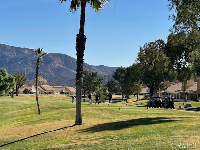 surrounding community with a mountain view and a lawn