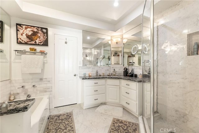 bathroom featuring vanity, backsplash, tile walls, and a tray ceiling