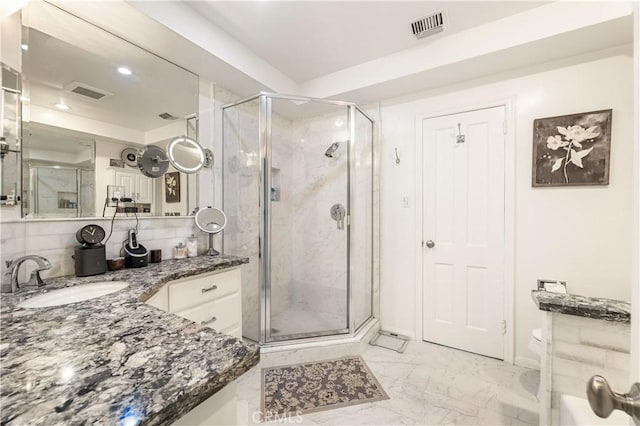 bathroom featuring a shower with shower door, toilet, vanity, and tasteful backsplash