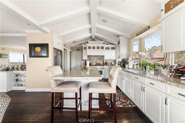 kitchen with tasteful backsplash, white cabinets, and a breakfast bar