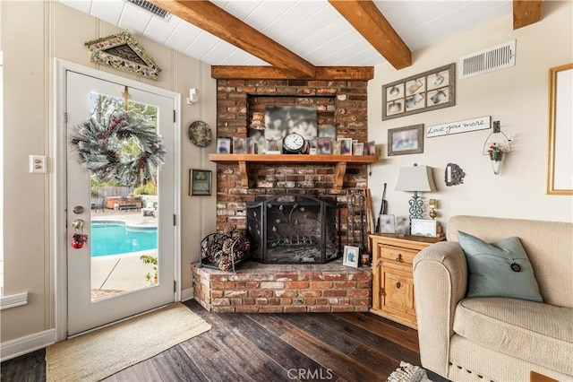 living room with a fireplace, dark wood-type flooring, and beamed ceiling