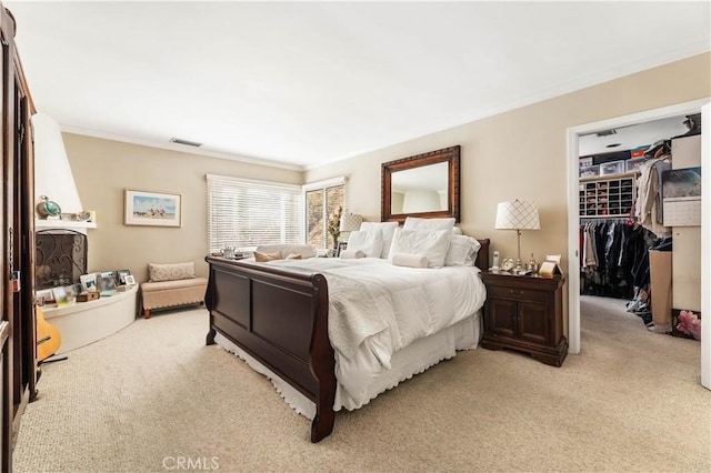 carpeted bedroom with a closet and crown molding