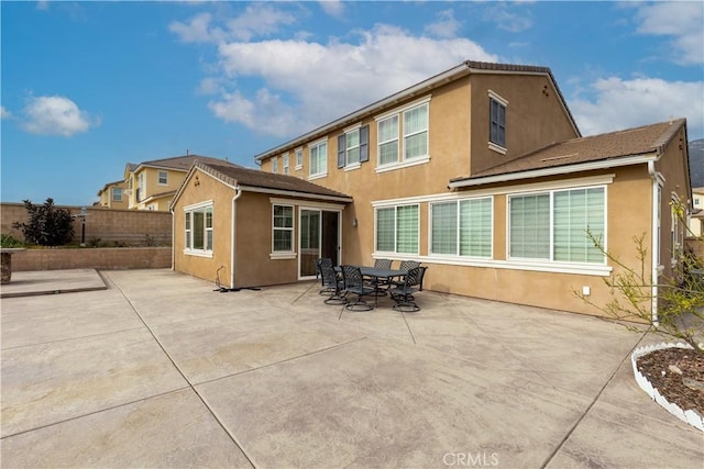 back of house with a patio area, fence, and stucco siding