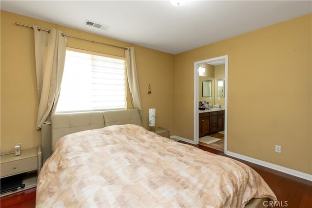 bedroom featuring connected bathroom, visible vents, dark wood finished floors, and baseboards