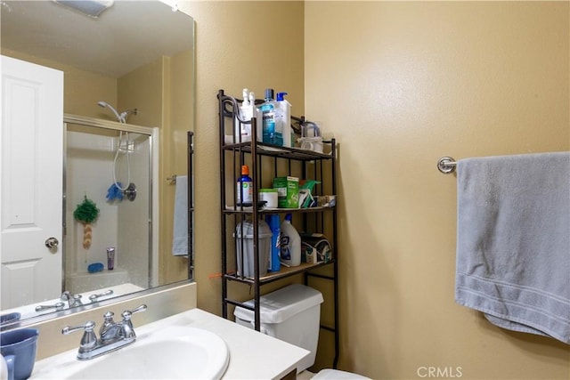 bathroom featuring toilet, a shower stall, and vanity