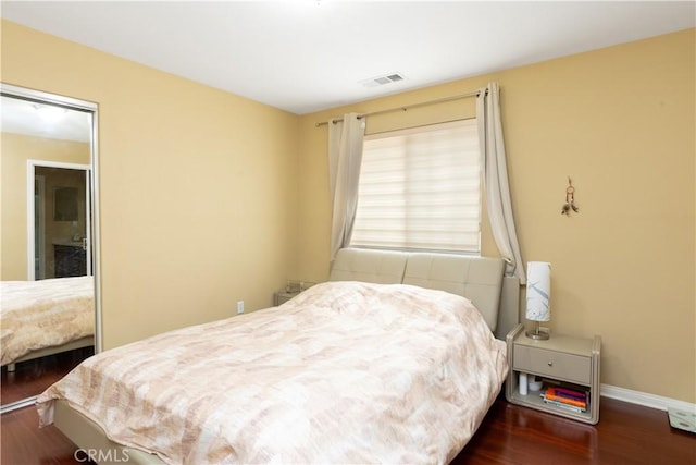 bedroom featuring dark wood finished floors, visible vents, and baseboards