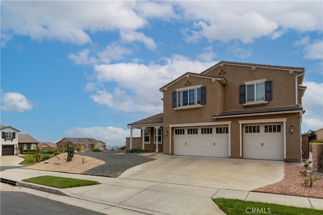 view of front of property featuring a garage, concrete driveway, a residential view, and stucco siding